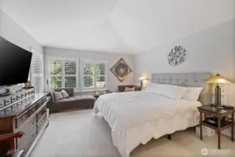 From this perspective, the primary bedroom reveals its full sense of space and tranquility. Soft natural light streams through large windows, highlighting elegant details.  The room’s layout effortlessly accommodates a sitting area or private reading nook, while offering sweeping views of the surrounding property.