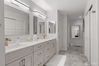 The primary suite’s bathroom is a luxurious retreat, designed with both elegance and functionality in mind. Dual sinks provide ample space for daily routines, while a freestanding soaking tub invites relaxation and indulgence. A large, glass-enclosed shower adds a modern touch, complementing the sophisticated finishes and serene ambiance. Every detail has been thoughtfully curated to create a spa-like experience within the comfort of home.