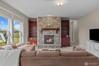The stone fireplace and custom built-ins with subtle undermount lighting create a warm and sophisticated focal point