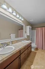 The upstairs bathroom boasts dual sinks and a roomy layout, combining practicality with a refined feel.