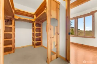 Custom built-ins offer plenty of storage in the primary suite walk-in closet
