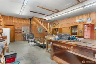 The large shop is heated (wood stove), insulated, plumbed... lots of power. Large upstairs storage area and two smaller side craft rooms, as well as lean-to's on each long side... a craftsman's dream.