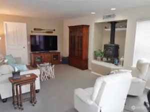 Family Room w/ a propane free-standing fireplace. The door leads to the Laundry Room and Garage.