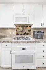 A gas cooktop and tile backsplash accent the kitchen beautifully.