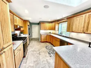 The door at the end of the kitchen opens to the large utility room.  There is also a powder room just off the laundry room with easy access from the kitchen, laundry and garage areas.