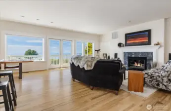 Great Room-style Living Room, Dining Room & Kitchen area on the 2nd level. Hickory flooring, propane gas Fireplace with slate surround and built-in WiFi stereo speakers.  French doors out to the 2nd level deck with views of the Sound & mountains.
