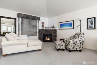 As you enter the Primary Ensuite, you are greeted by a comfortable sitting area and a propane gas fireplace with stone surround. Custom Curtains and plush carpeting.