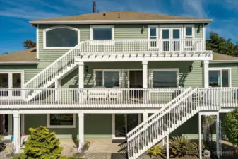 This view of the home shows the back side that faces the Sound & Mountains and the intricate layout of the multilevel deck system.