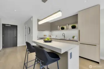 Beautiful Kitchen with 2 tier island counter and custom installed lighting above, built in fridge and cabinets