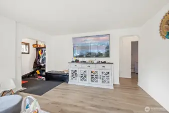 Living Room with hallway that leads to 2 bedrooms, 3/4 bath and stairs leading to 2nd floor.