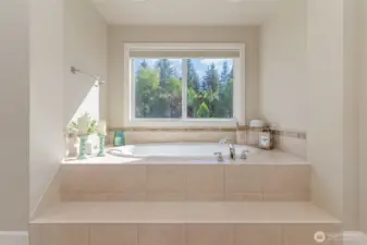 Soaking tub faces the private greenbelt.