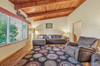 Entering front door to living room with vaulted wood celilings
