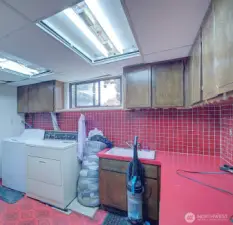 This house features a hardworking laundry located in the lower level of home with vintage red tiling.