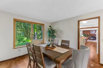 Dining room with backyard facing windows and transition into kitchen.