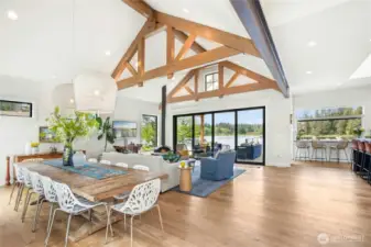 The great room features elevated ceilings with custom wood beams, a wood burning floating fireplace and 16' sliding doors open wide to allow amazing indoor/outdoor living.