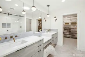 The ensuite primary bath and walk-in closet with built-ins.