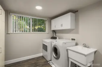 Light and bright oversized laundry with utility sink.