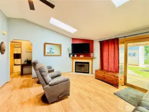 Living room is the hub of the home with access to the covered patio and fully fenced backyard, vaulted ceilings, skylights for natural light, updated lighting