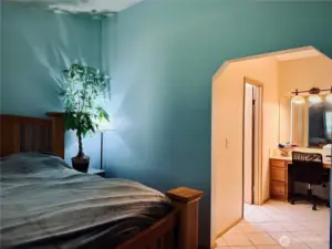 Primary Bedroom view from bedroom towards makeup counter and 3/4 bathroom to the left, dual closets on right side.