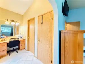 Primary bedroom view from bedroom towards makeup counter and dual closets, 3/4 bathroom on the left.