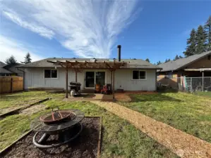 7703 NE 156th Ave sits on a large lot with outbuildings, covered patio, and garden beds waiting for you