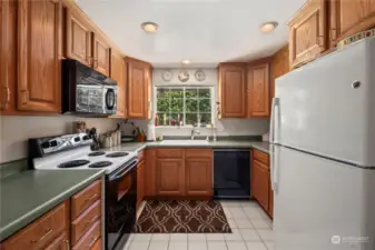 Generously sized kitchen with warm toned cabinets.