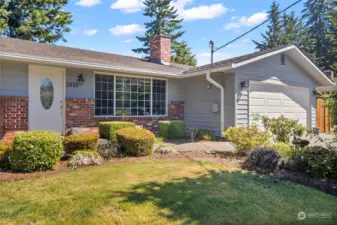 Front of the home boasts mature landscaping and two car garage.