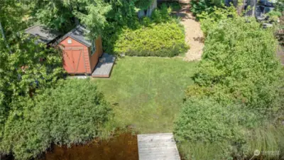 Aerial view of the lower yard showing the boathouse, yard space, and beginning of the floating dock.