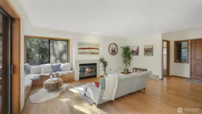 Spacious living room with wall of windows offering waves of natural light and scenic views of the lake and Mount Rainier.