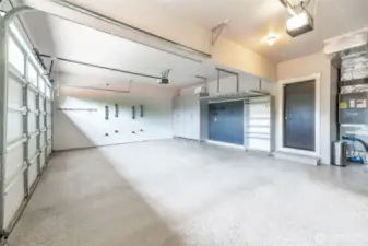 3 car garage with well designed storage, EV charger, epoxy floor & wall mounted bike racks.