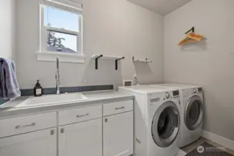 2nd floor laundry with storage, utility sink and washer and dryer