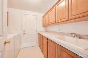 Look at this utility room! Ample cabinets and counterspace~washer and dryer stay