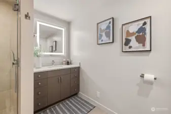 Updated primary bathroom featuring a stunning shower and a backlit mirror.