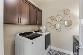 Large laundry room with plenty of storage space and countertop.Designer tile floors as well.