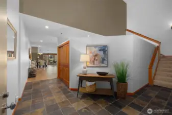 Inviting entry foyer with slate tile flooring, custom millwork, and a spacious, gallery-like welcome home moment.
