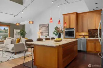 Chef-inspired kitchen with stone countertops, designer pendant lighting, and ample prep and gathering space.