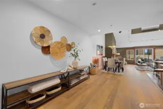 Wide-plank flooring and thoughtful wall detailing create a gallery-like hallway that adds depth and character to the home.