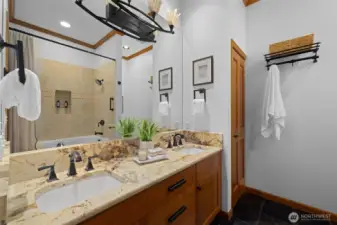 Thoughtfully updated bathroom with stone-topped vanity, modern fixtures, and warm, inviting finishes.
