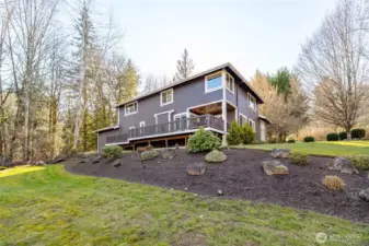 Mature landscaping and sweeping lawns surround the home, offering a serene, park-like backdrop