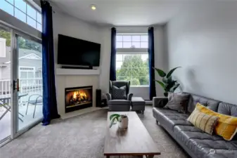 Extended ceilings, plenty of windows and a cozy fireplace make for an inviting living space!