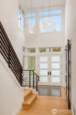 Sprawling and light drenched 2 story entry accentuated by stunning custom tile floor detail and dramatic contemporary hanging light fixtures