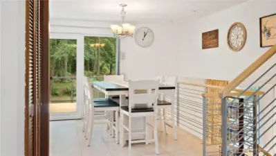 Staircase leading to upper and lower level + Dining.