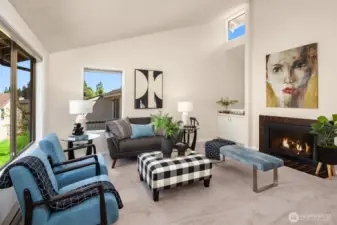 Cathedral ceilings and a cozy fireplace make this home feel welcoming and spacious.