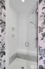 Upgraded shower with seat and niche.