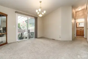 Formal dining room and hallway to the two extra bedrooms and bathroom. Sliding glass door leads to covered patio in the backyard.