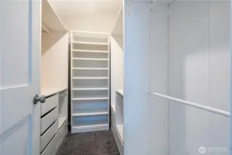 Spacious walk-in closet with built-in drawers and custom shelving