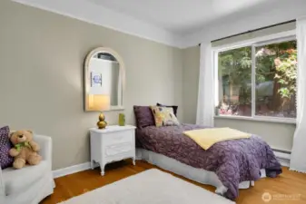 Serene main floor bedroom with backyard outlook,original trim, picture rail, new paint & lighting.