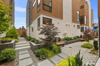 Tucked between these homes, beautifully landscaped gated courtyards create a serene community feel.  Paver walkways meander through lush plantings, mature maple trees, and blooming hydrangeas.  Benches offer quiet spots to relax or gather with neighbors. A rare blend of nature and neighborhood in the heart of the city.
