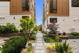 Tucked between these homes, beautifully landscaped gated courtyards create a serene community feel.  Paver walkways meander through lush plantings, mature maple trees, and blooming hydrangeas.  Benches offer quiet spots to relax or gather with neighbors. A rare blend of nature and neighborhood in the heart of the city.