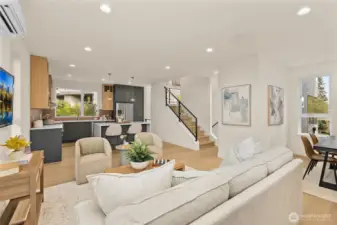 Sunlit great room with wide plank floors and generous windows. A comfortable gathering space designed for daily life and entertaining.